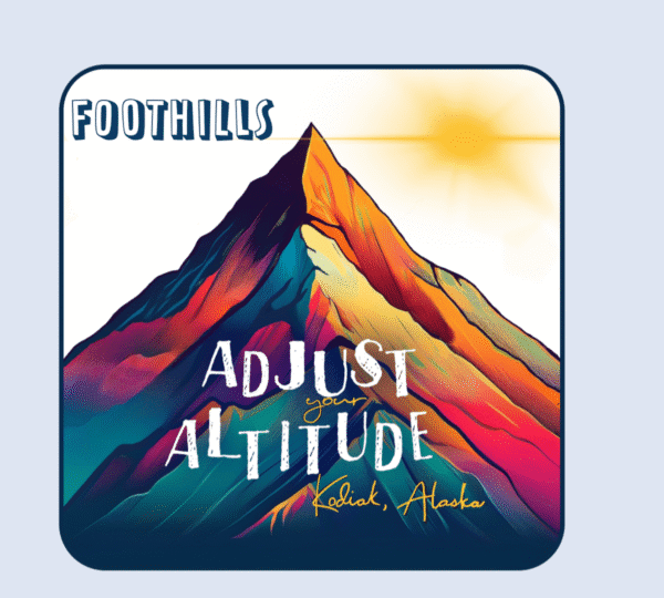 A colorful, stylized mountain with a bright sun in the sky captures the spirit of Kodiak. Text reads “FOOTHILLS” at the top and “Adjust your altitude, Kodiak, Alaska” across the center and bottom.