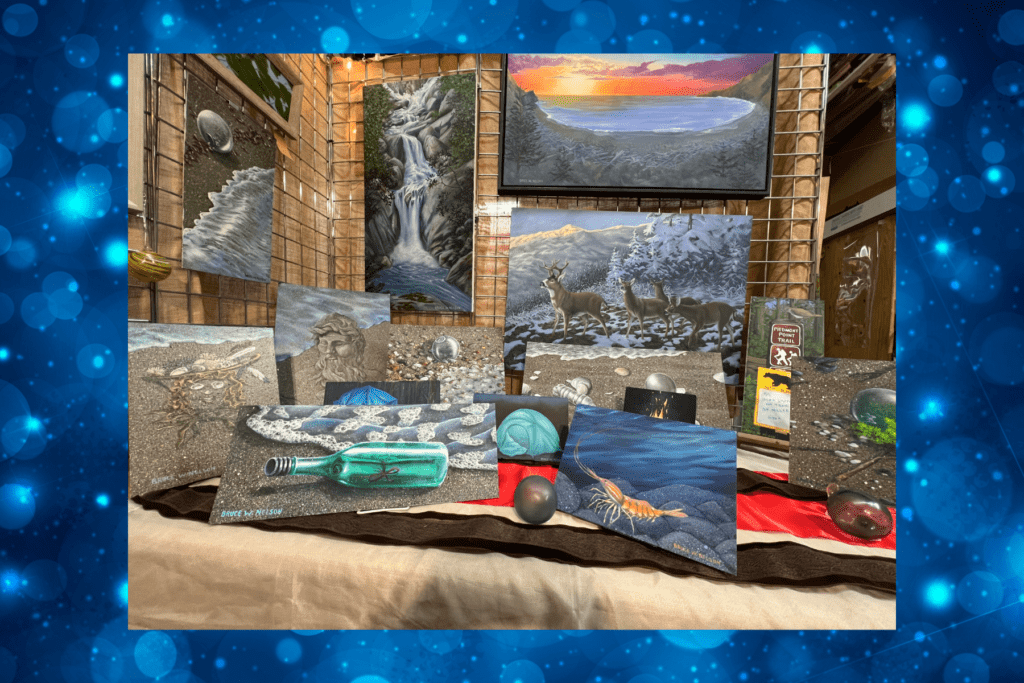 A display of paintings on easels and a table, featuring nature scenes with waterfalls, sunsets, deer, and fantasy elements—perfect as Holiday gifts in Kodiak—set against a blue, bokeh-patterned border at The Frame Shop.