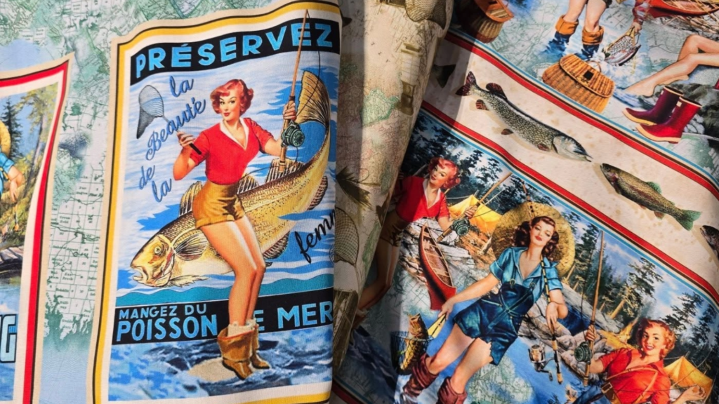 A colorful patterned fabric from a fabric shop in Kodiak features vintage-style illustrations of women fishing, holding rods and fish, with French text and scenic outdoor backgrounds, reminiscent of retro travel or advertising posters.
